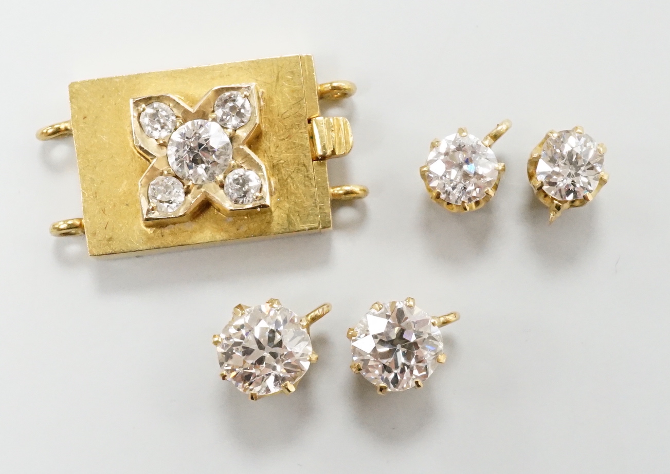 Four yellow metal and diamond set pendants and a diamond set yellow metal clasp.